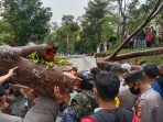 Evakuasi dua penumpang dalam mobil petugas bersama warga