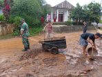 Babinsa bersama warga setempat membersihkan matrial yang terbawa banjir