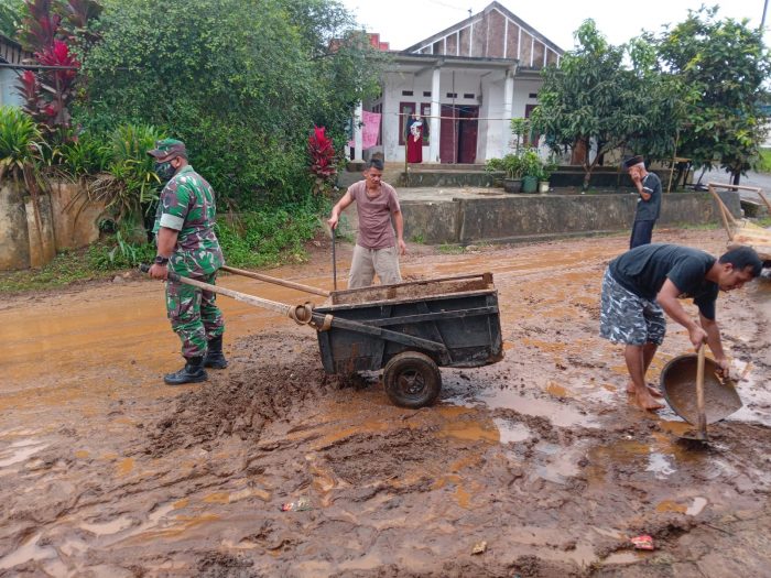 Babinsa bersama warga setempat membersihkan matrial yang terbawa banjir